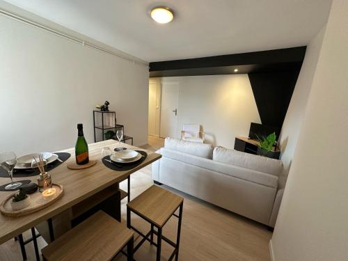 un salon avec un canapé blanc et une table dans l'établissement Le chal'heureux, Appartement chic au cœur d'Épernay, à Épernay