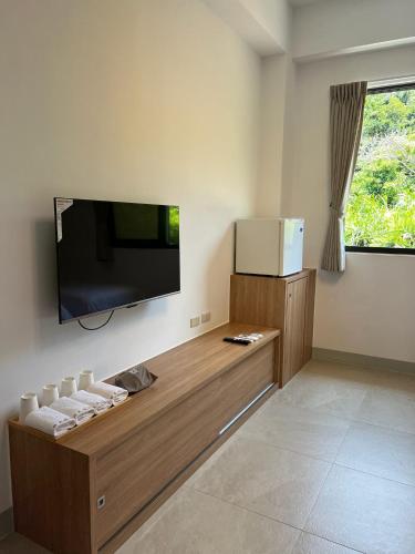 a living room with a flat screen tv on the wall at Dawn Valley in Green Island