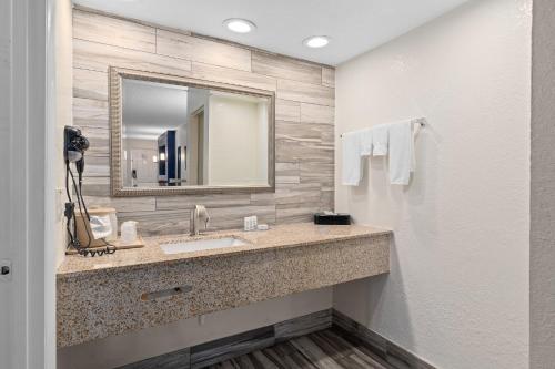 a bathroom with a sink and a mirror at Baymont by Wyndham Orlando Downtown in Orlando