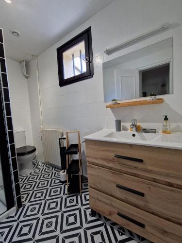 une salle de bain avec un lavabo et un miroir dans l'établissement Parenthèse Bergeracoise, à Bergerac