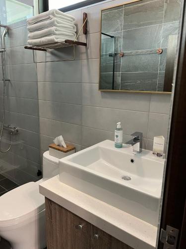 a bathroom with a sink and a toilet and a mirror at Dawn Valley in Green Island