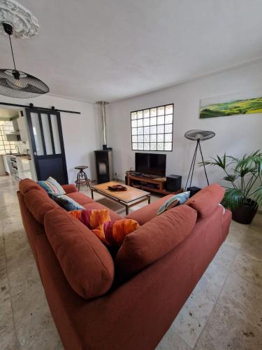 - un salon doté d'un canapé brun dans l'établissement Parenthèse Bergeracoise, à Bergerac