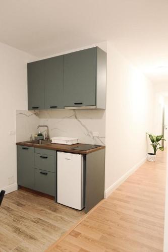 een keuken met grijze kasten en een aanrechtblad bij Apartment 103 in Tirana