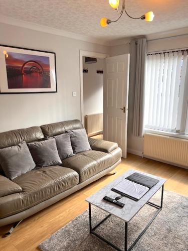 a living room with a couch and a coffee table at Kelpies Serviced Apartments- McLaughlan in Falkirk