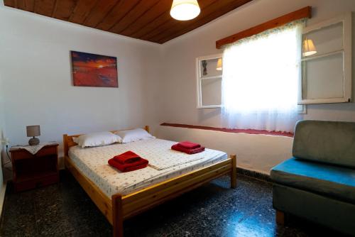 a bedroom with a bed with two red towels on it at Nature of Karapata in Koroni