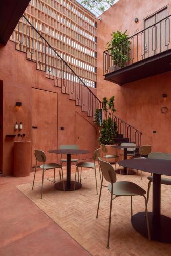 a room with tables and chairs and a staircase at Casa Cunda in Oaxaca City
