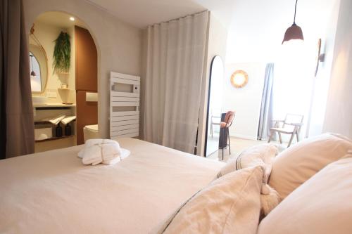 a bedroom with a large white bed with a mirror at Maison Bello - Cosy in Beaupréau