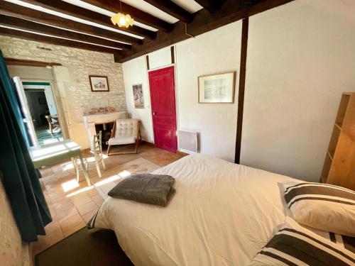 a bedroom with a bed and a red door at Charmant gîte familial en Touraine avec cheminée - FR-1-381-617 in Verneuil-le-Château