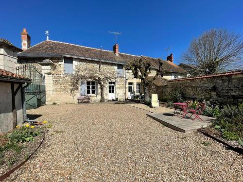 an old stone house with a gravel yard at Charmant gîte familial en Touraine avec cheminée - FR-1-381-617 in Verneuil-le-Château