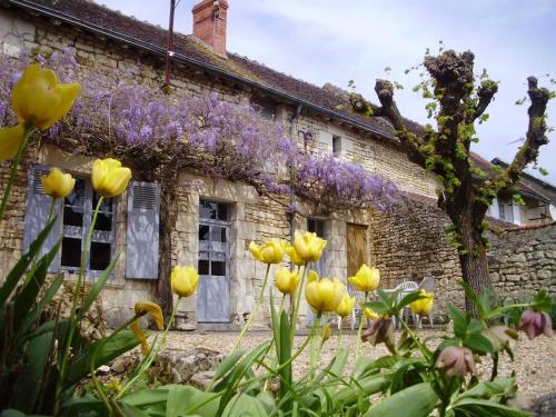 an old stone house with flowers in front of it at Charmant gîte familial en Touraine avec cheminée - FR-1-381-617 in Verneuil-le-Château