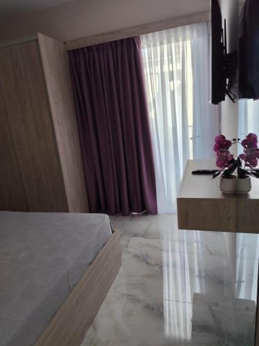 a bedroom with a bed and a table with flowers on it at Casa Helone 2 in Polykhrono