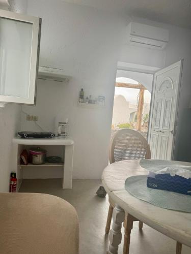 a kitchen with a table and chairs and a door at Sakas Residences in Karterados