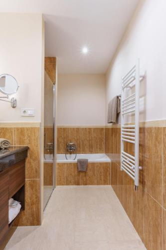 a bathroom with a tub and a sink at Monika Apartment in Bogács