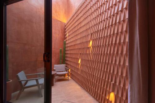 a hallway with a wooden wall with a table and chairs at Casa Cunda in Oaxaca City