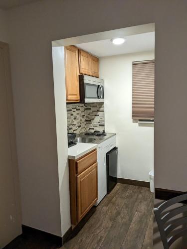 a small kitchen with a stove and a microwave at Downtown Hollywood Gardens Inn & Suites in Hollywood