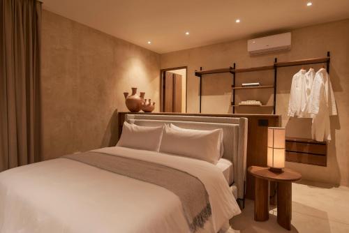 a bedroom with a large white bed and a lamp at Casa Cunda in Oaxaca City