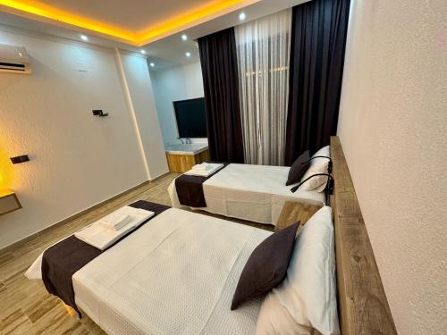 a hotel room with two beds and a television at Kalkan da Vaıllant Villa in Kaş