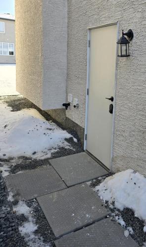 a door to a building with snow on the ground at Jaykay executive suite in Winnipeg