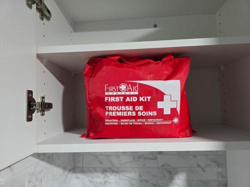 a red first aid pillow sitting on a shelf at Jaykay executive suite in Winnipeg