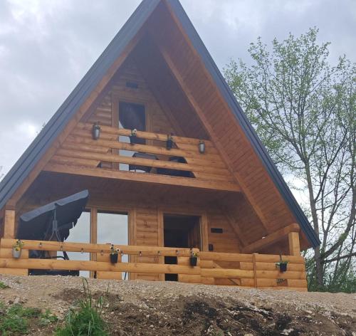 a large wooden house with a pitched roof at Cottage MIRNI RAJ in Jajce