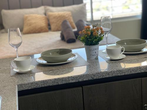 a table with two wine glasses and a vase of flowers at 17 Apartamento en Santiago en frente a Metro - Estadio - Hipodromo de Chile in Santiago