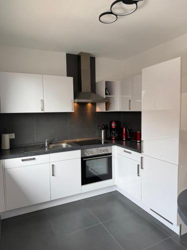 a kitchen with white cabinets and a sink at Ferienwohnung Klaus in Clausen