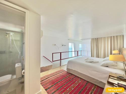 a bedroom with a large bed and a shower at Loft Praia - Meireles in Fortaleza
