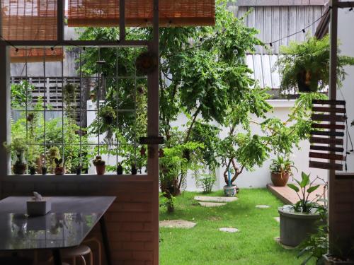 a garden with potted plants and a table at A Little Nap Hometel in Hat Yai
