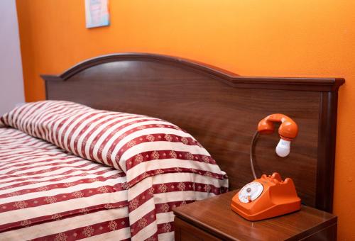 a bed with a phone on a table next to it at Soprattutto in Montalbano Jonico