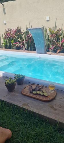 ein Teller mit Essen neben einem Swimmingpool in der Unterkunft Casa do Bougainvillea Mundaú-Trairi-Ce in Mundaú