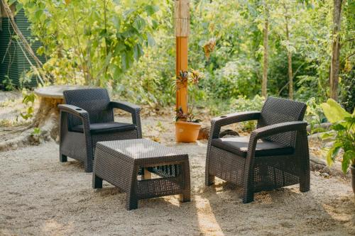 a group of chairs and a table in a yard at Chilamate Rainforest Beach Retreat in Nosara
