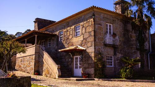 a large stone house with a white door at Villa Miranda Heritage House in Creixomil