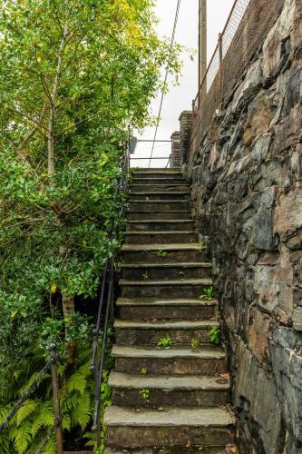 a set of stairs next to a stone wall at Dinbnb Homes I Luxury Villa with Hot Tub & Views in Bergen