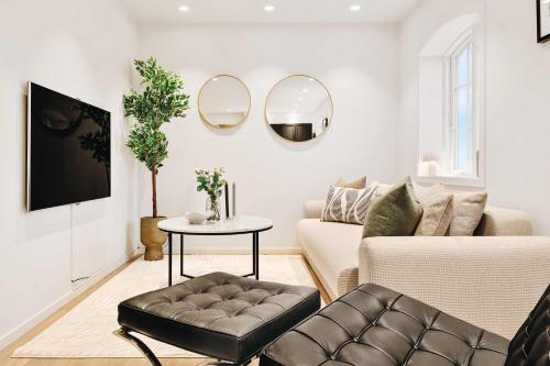 a living room with a couch and a table and mirrors at Dinbnb Homes I Luxury Villa with Hot Tub & Views in Bergen