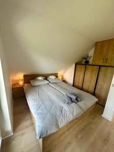 a bedroom with a large bed with white sheets and pillows at OdpocznieszTU in Brzozowa