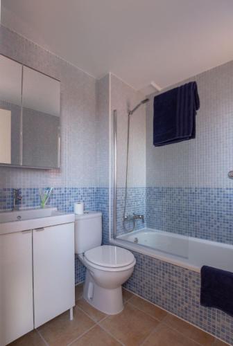 a bathroom with a toilet and a tub and a sink at Alíseos in Costa de Antigua