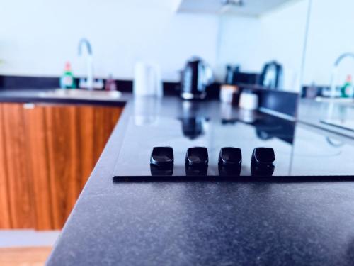 a black counter top with three black shoes on it at Clara Place in Barking - One Bedroom in Barking