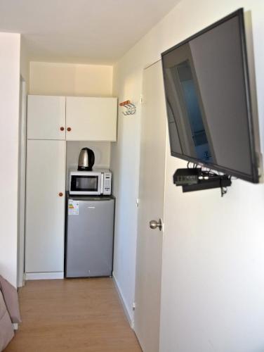 a room with a television on a wall with a refrigerator at Trinidad Inn Trinidad in Trinidad