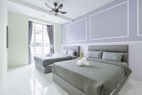 ein Schlafzimmer mit zwei Betten und einem Deckenventilator in der Unterkunft Lavender Dream Cozy Family 10 Pax Clover Home 8-01 in Brinchang