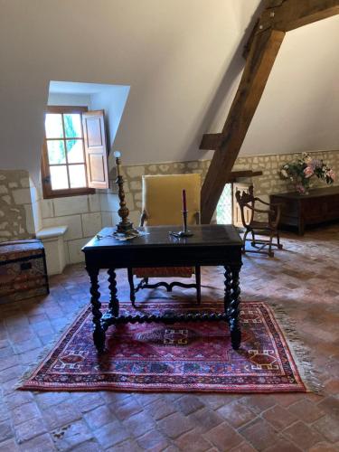 a room with a wooden table on a rug at Cambraye in Marcilly-sur-Vienne