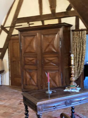 a wooden cabinet with a candle on top of a table at Cambraye in Marcilly-sur-Vienne