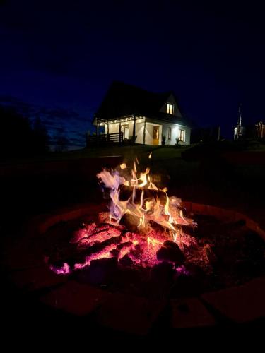 a fire pit in front of a house at night at OdpocznieszTU in Brzozowa