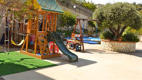 a playground with a slide and a swing at Rigoletto Cilento with private garden and pool in Eredita