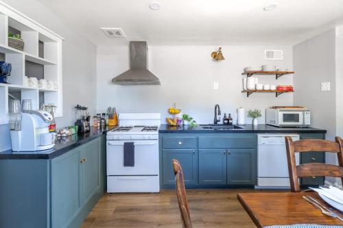 a kitchen with blue cabinets and white appliances at Scenic Mountain Getaway by the Park in Flagstaff