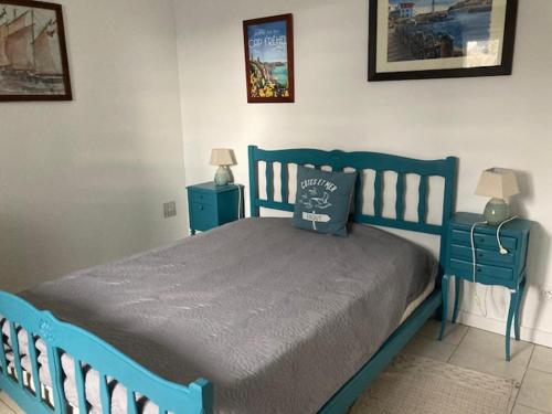 - un lit bleu dans une chambre avec 2 tables de nuit dans l'établissement L'Abricotier, à Fréhel