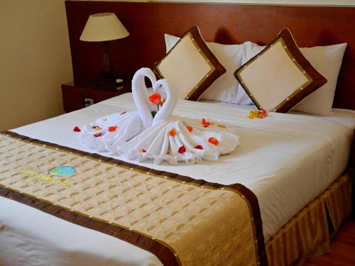 a bed with two swans dressed in white at Hau Giang Hotel in Can Tho