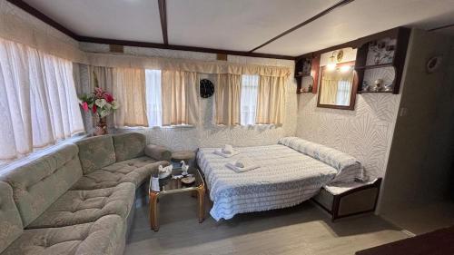 a living room with a couch and a bed at Bungalow modulo con jardin in El Bosque