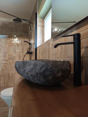 La salle de bains est pourvue d'une grande baignoire en pierre. dans l'établissement La Ferme De la baie, à Favières