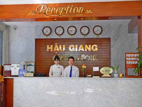 two people standing behind a counter in a restaurant at Hau Giang Hotel in Can Tho