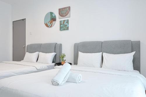 two beds with white sheets in a bedroom at Elegant Studio Escape at Emerald Avenue Cameron Clover Home 4-03 in Brinchang
